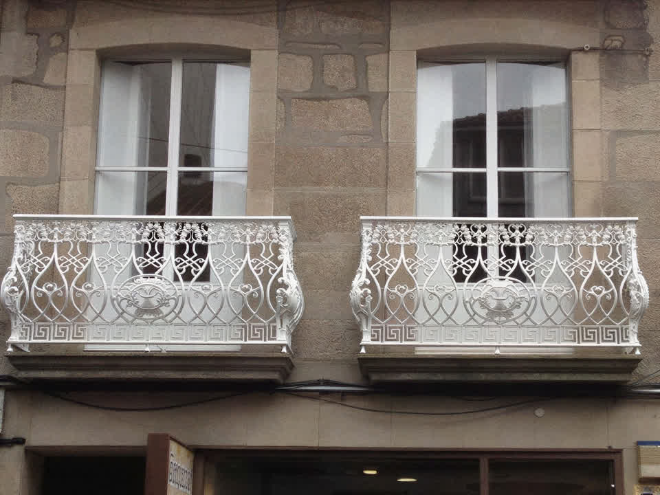Balcones de fundición restaurados en una fachada de piedra de Pontevedra
