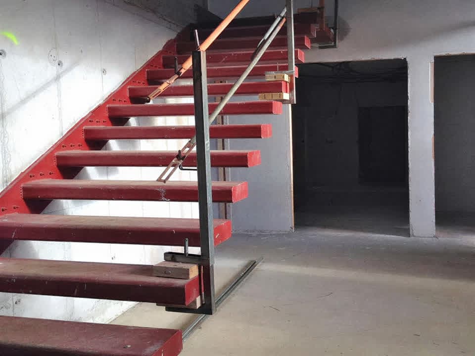 Escalera metálica de cerrajería con peldaños rojos en Pontevedra